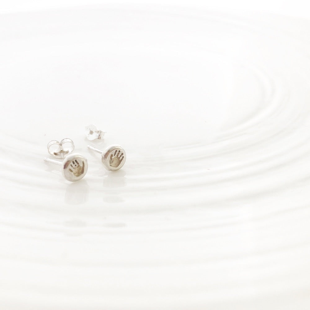 Our small stud earrings are the perfect way to show off your child's tiny hands. They're small enough to wear every day, with prints that can be left as natural silver or darkened for a bolder look. These earrings are made from 100% sterling silver, with posts and backs included.