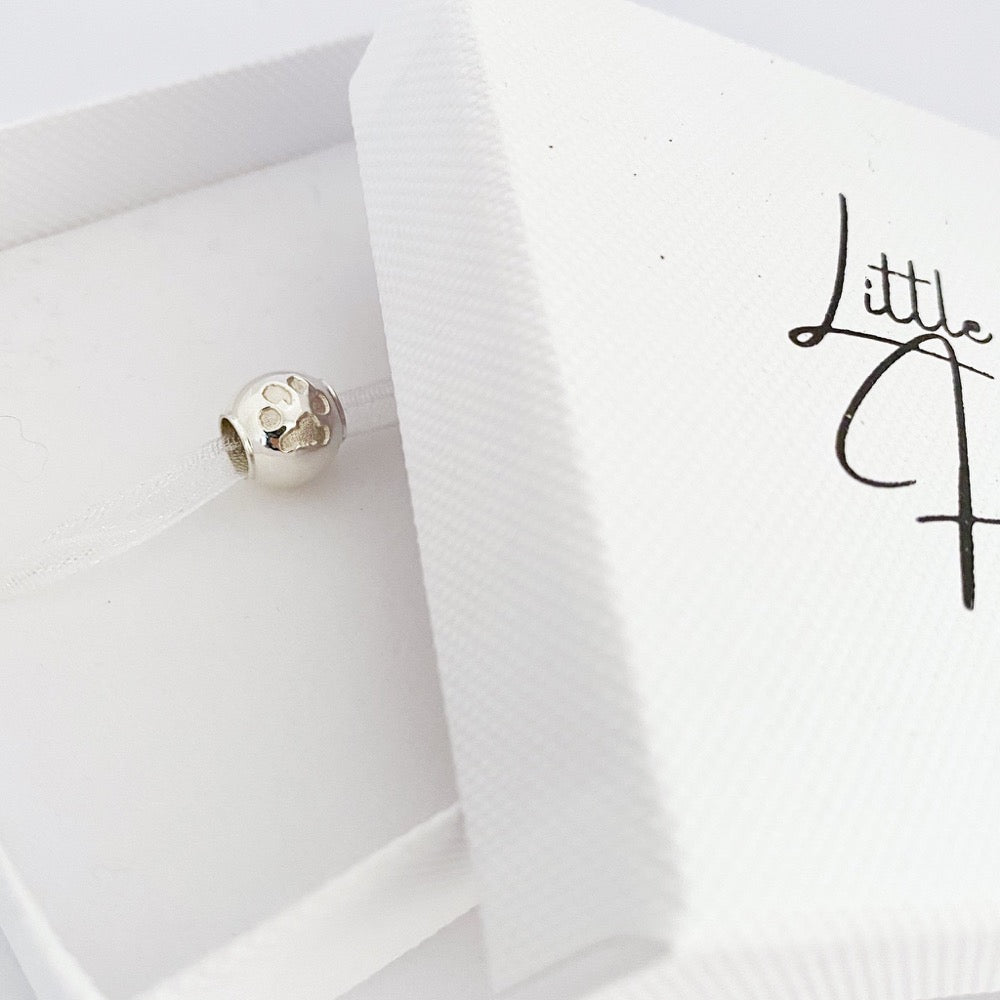 This beautiful bead is personalized with the true pawprints of your pet. 